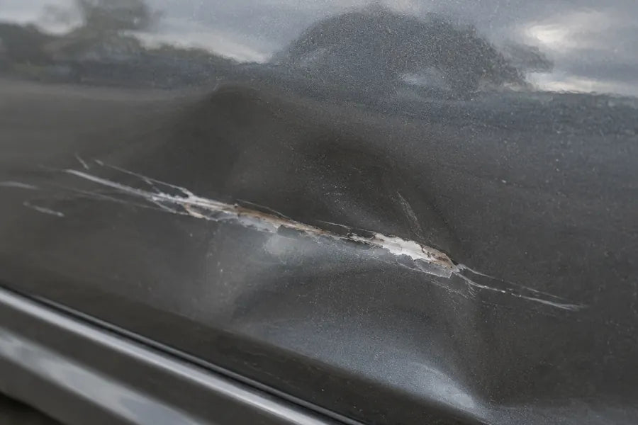 Delle mit Schramme in einer grauen Autotür